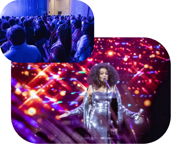A crowd watches a live concert. In the foreground, a woman in a sparkling silver outfit sings on stage, with colorful lights and abstract patterns projected behind her.
